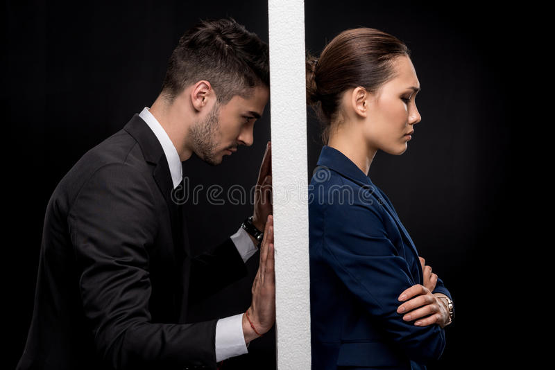 side-view-sad-couple-formal-wear-separated-wall-isolated-black