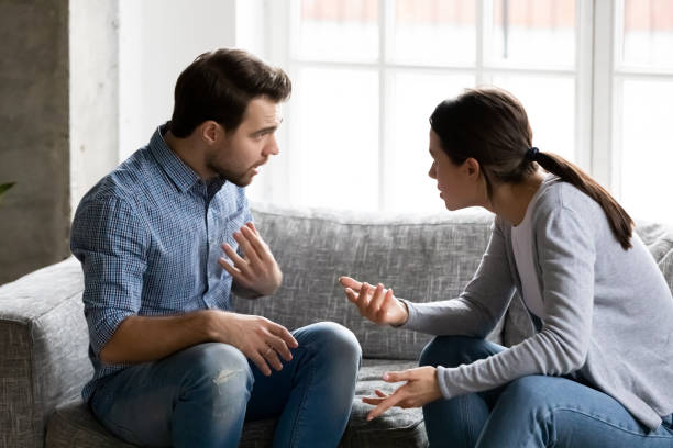 couple-fighting-angry-man-womna-politikakritis-Stressed young married family couple arguing emotionally, blaming lecturing each other, sitting on couch. Depressed husband quarreling with wife, having serious relations communication problems.
